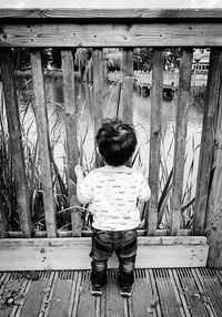 Rear view of boy playing on wooden floor