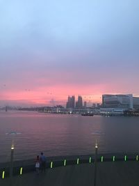 High angle view of sea by buildings against sky at sunset