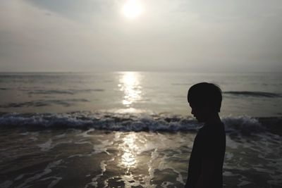 Silhouette man on beach against sky