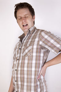 Smiling young man looking away against white background