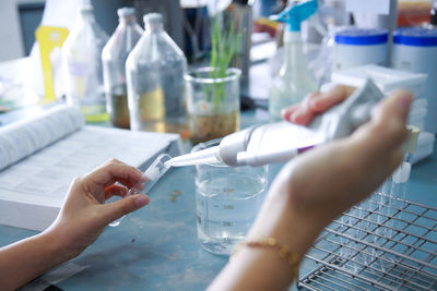 Cropped hands of scientist examining chemical in laboratory