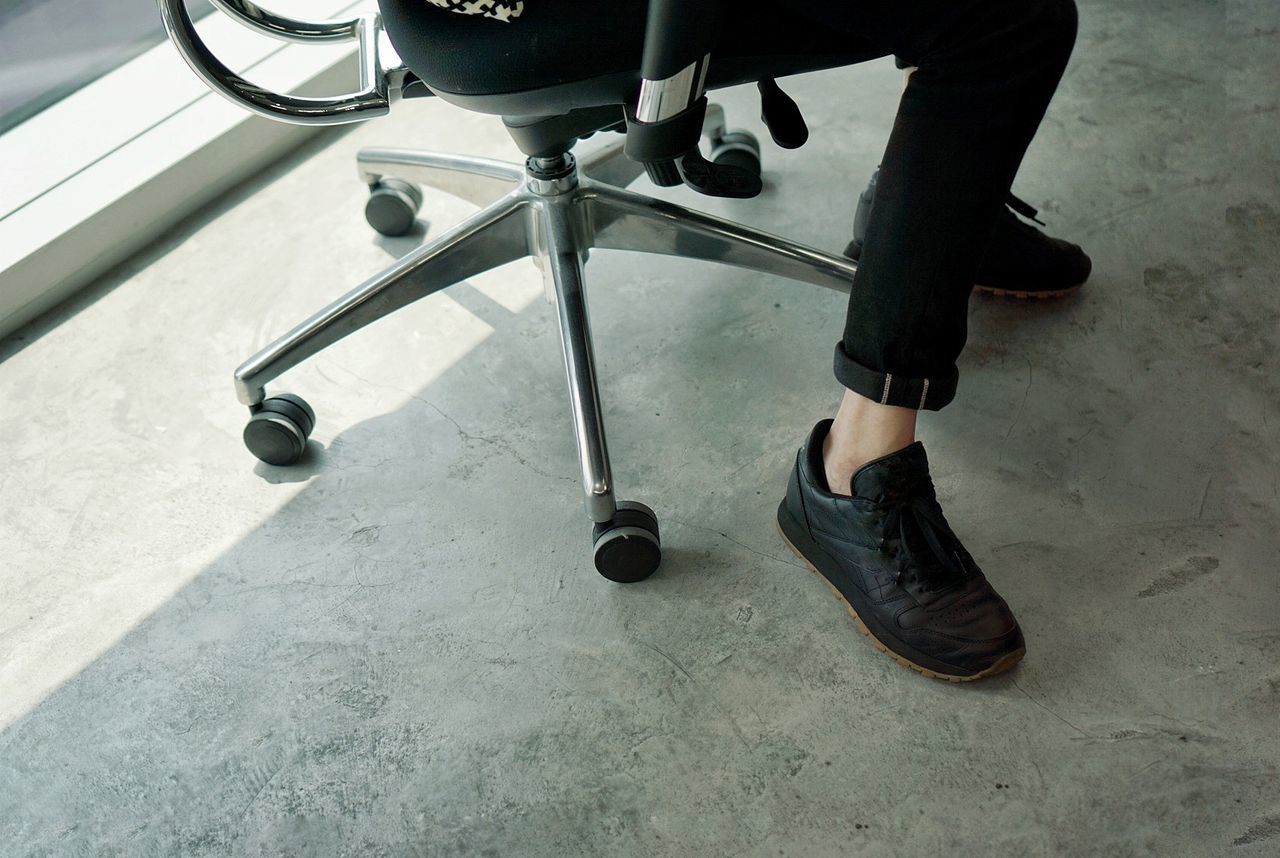 LOW SECTION OF MAN WEARING SHOES ON FLOOR