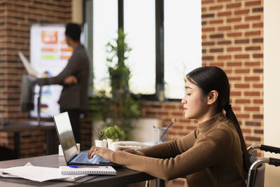 Young woman using laptop at office