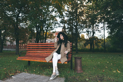 Portrait of young woman sitting at park