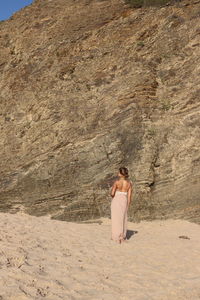 Full length of woman standing on sand