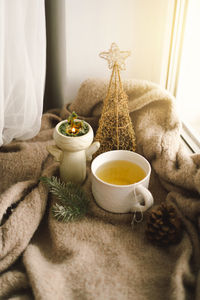 Hot tea, candles, christmas golden balls and decorations. christmas holiday mood