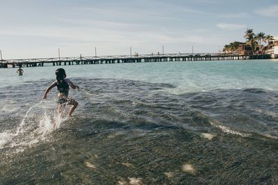 Full length of woman jumping in sea