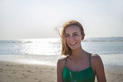 Portrait of young woman standing at beach