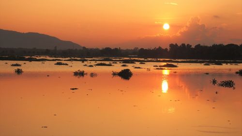 Scenic view of lake against romantic sky at sunset