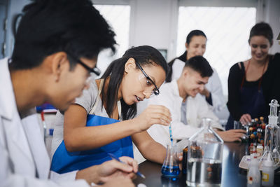 Young multi-ethnic students mixing solutions at chemistry laboratory