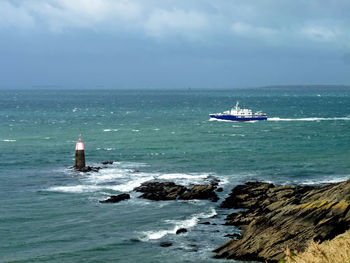 Boats on sea against cloudy sky