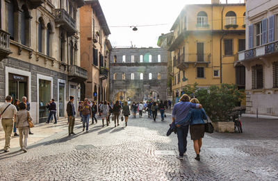 People walking on street amidst buildings in city