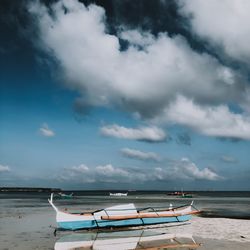 Boats moored in sea against sky