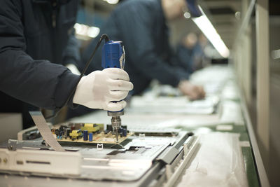 Midsection of workers working in factory