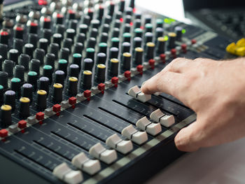 Cropped hand of man mixing music in recording studio