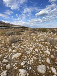 Surface level of stones on field against sky