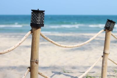 Close-up of rope tied on wooden post at beach