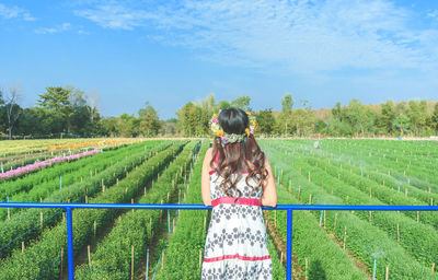 Rear view of woman on field against sky
