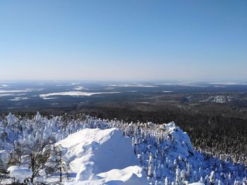 Aerial view of snowcapped landscape against blue sky