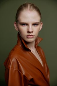 Portrait of young woman against black background