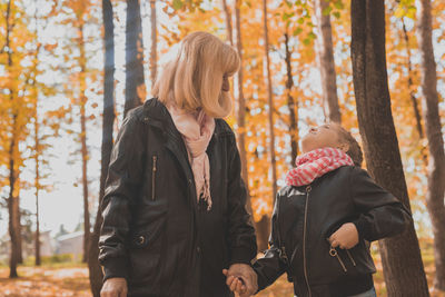 Woman wearing mask in forest during autumn