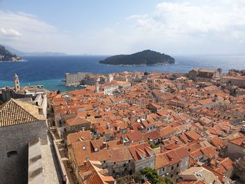 High angle view of townscape by sea against sky