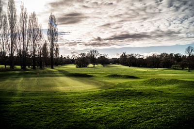 Scenic view of golf course against sky