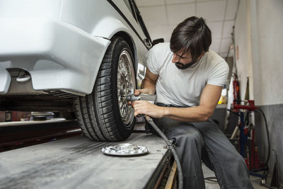 Man repairing car in factory