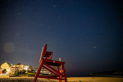 Lifeguard chair underneath the stars on the beach.