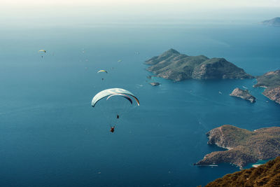 People paragliding over sea