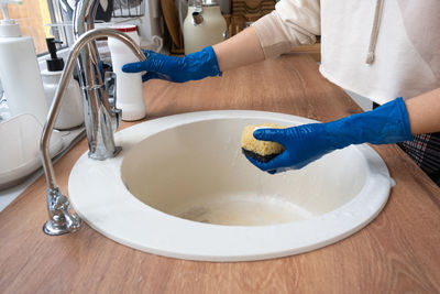 Midsection of woman washing hands in bathroom