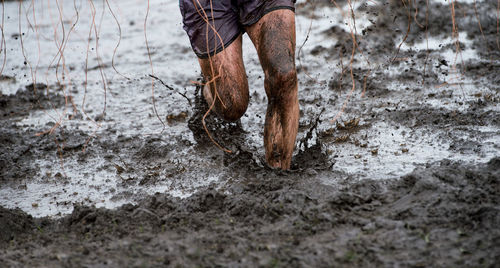 Low section of man running in mud