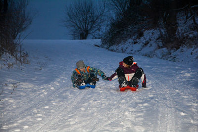 People on field by snowcapped mountain during winter