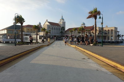 Group of people on road by buildings in city