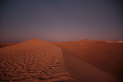 Scenic view of desert against sky during sunset