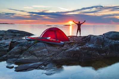 Man standing on rocks by tent