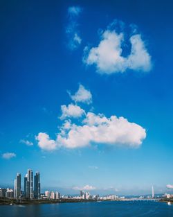 Buildings in city against cloudy sky