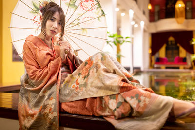 Portrait of beautiful woman wearing traditional clothing sitting indoors