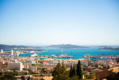 High angle view of city by sea against clear sky