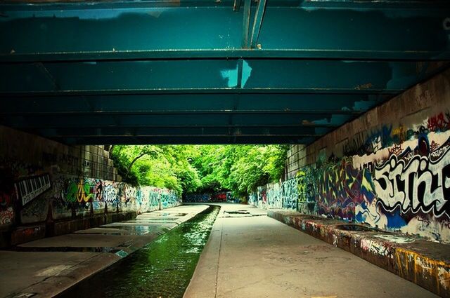 graffiti, the way forward, diminishing perspective, built structure, architecture, transportation, vanishing point, empty, wall - building feature, art, street, building exterior, walkway, art and craft, outdoors, day, no people, road, creativity, text