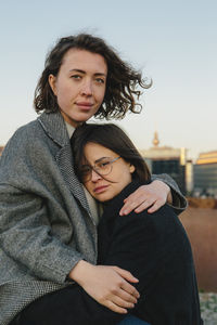 Portrait of lesbian couple embracing on rooftop