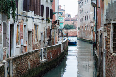 Canal amidst old buildings in city