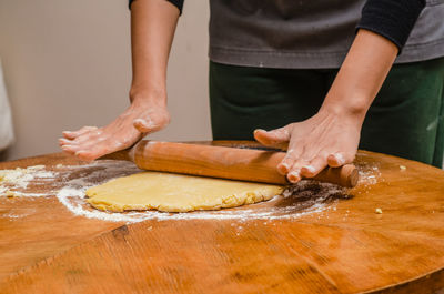 Rolling out cookie dough with a wooden splinter on the table