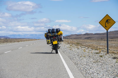 Adventure motorbike parked next to wind warning sign in argentina