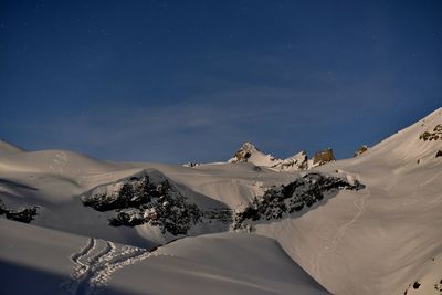 Scenic view of snow covered mountains against sky