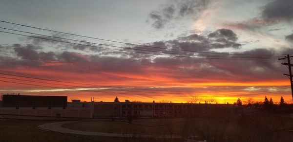 Silhouette city against sky during sunset