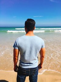 Rear view of man standing on beach