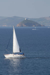 Sailboat sailing on sea against sky