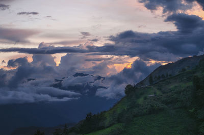 Scenic view of dramatic sky over silhouette mountain