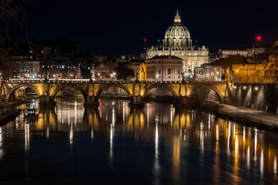 Illuminated bridge over river at night